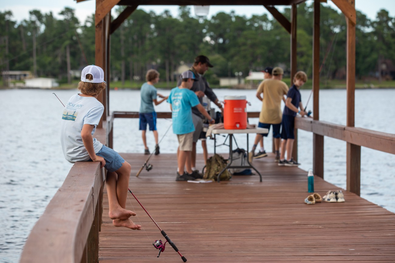 ambient photo of campers by the lake fishing