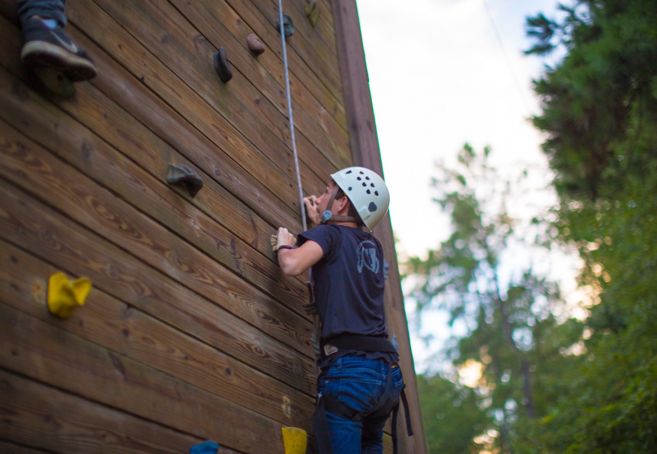 a summer camp boy climbing the climbing wall