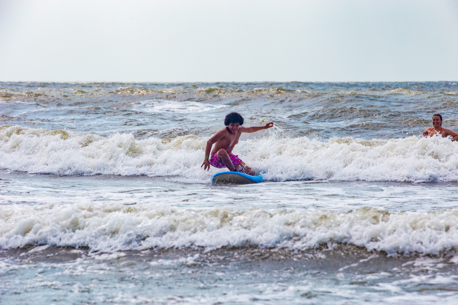 Camper riding a wave on a surfboard in the ocean