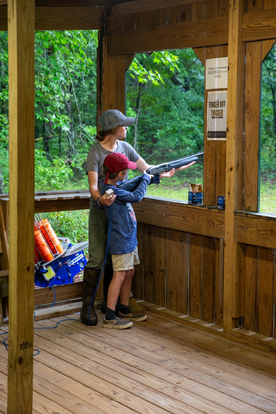 Instructor coaching a camper at the shooting sports range